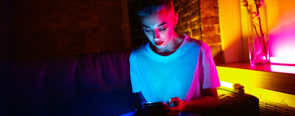 Young woman scrolls through her phone and sees shock advertising.