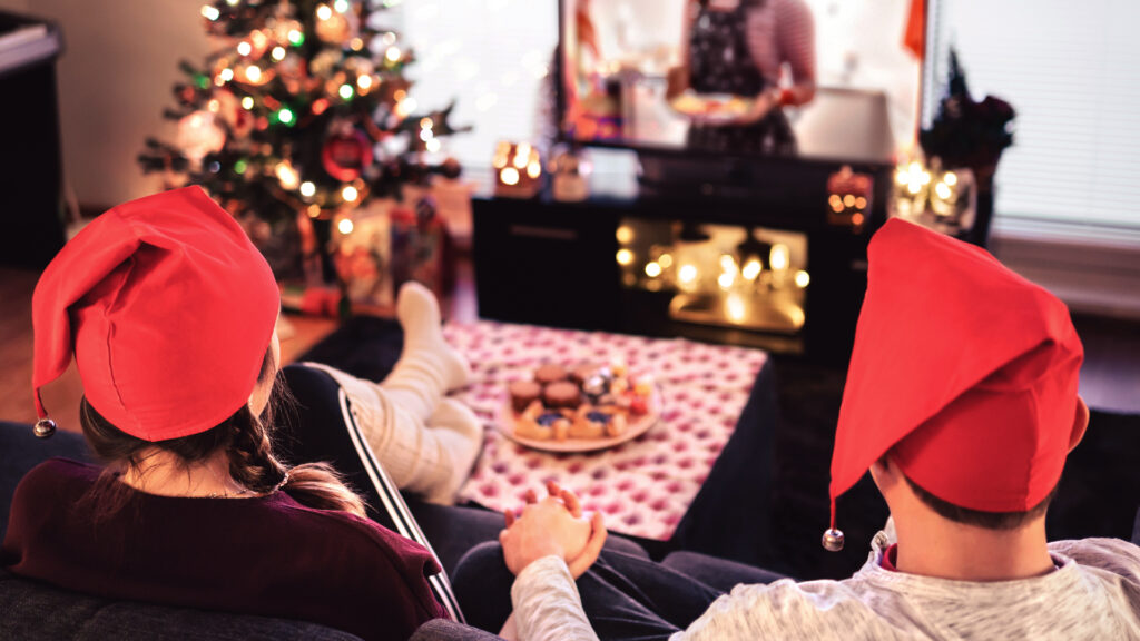 Couple watching Christmas TV adverts at home